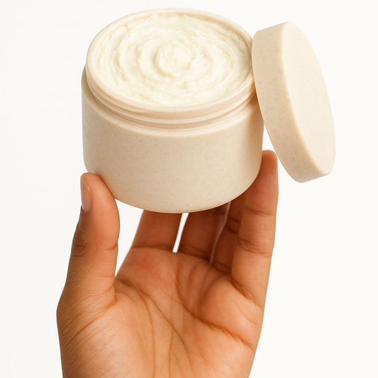 Hand holding a jar of whipped body butter showing its size and soft texture